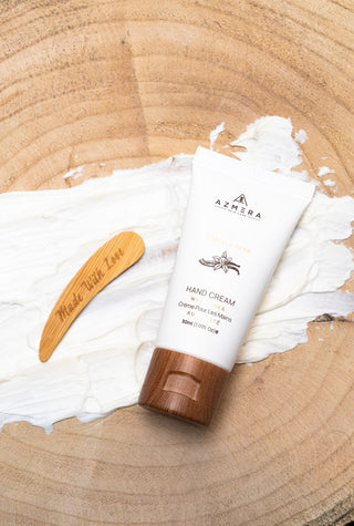 Shea hand cream with vanilla bean, spread out over a wood backdrop.
