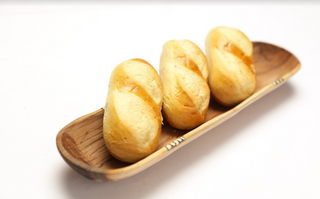 Wood tray with three breads on top