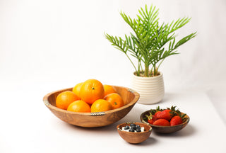 Round bowl next to smaller versions full of fruit